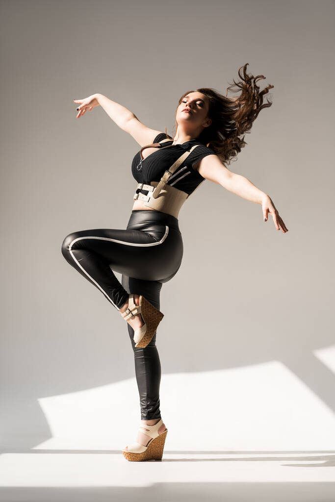 Модель plus size с большой грудью, танцующая в студии, концепция позитивного тела - Фото, изображение
