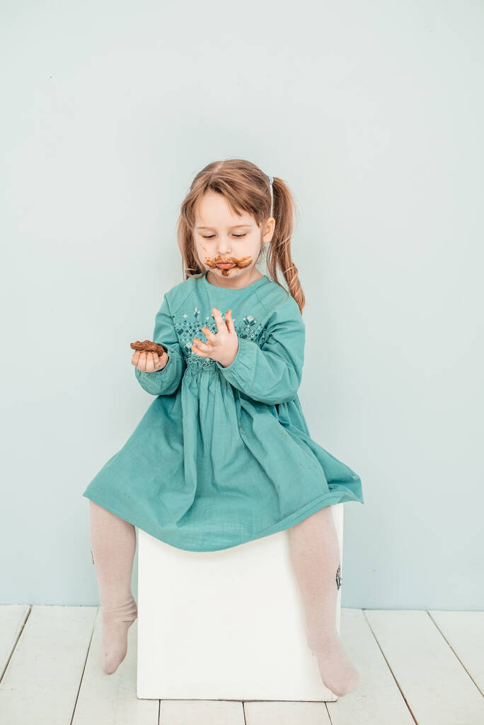 Adorable niña con la cara cubierta de chocolate - Foto, imagen