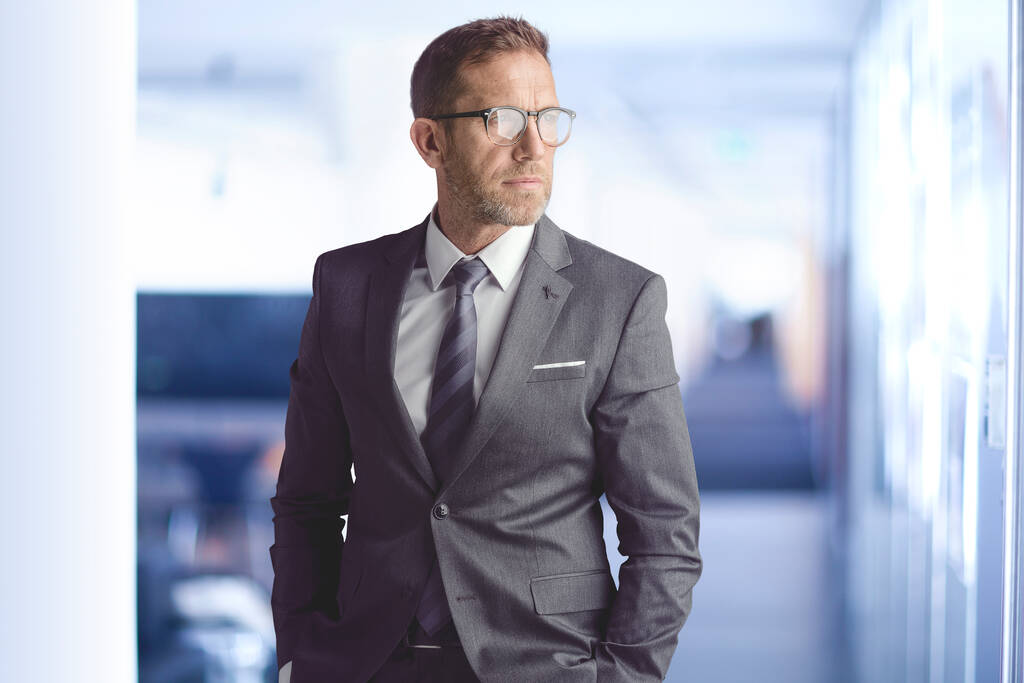 Portrait of serious face businessman wearing suit and eyeglasses while standing at the office. - Photo, Image