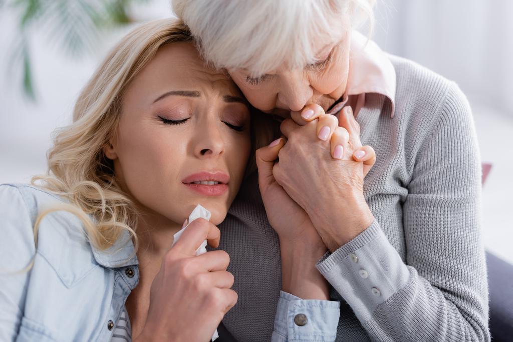 Ältere Frau beruhigt unzufriedene und weinende Tochter  - Foto, Bild