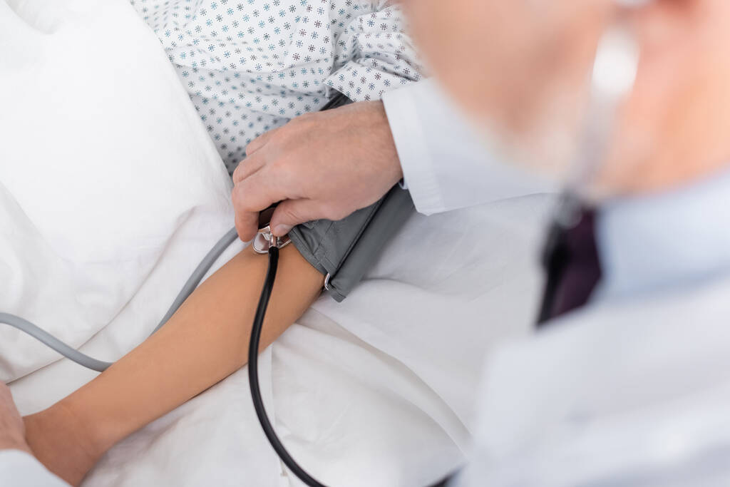 病院の女性に対する血圧計を使った医師の部分的見解前景がぼやけ - 写真・画像