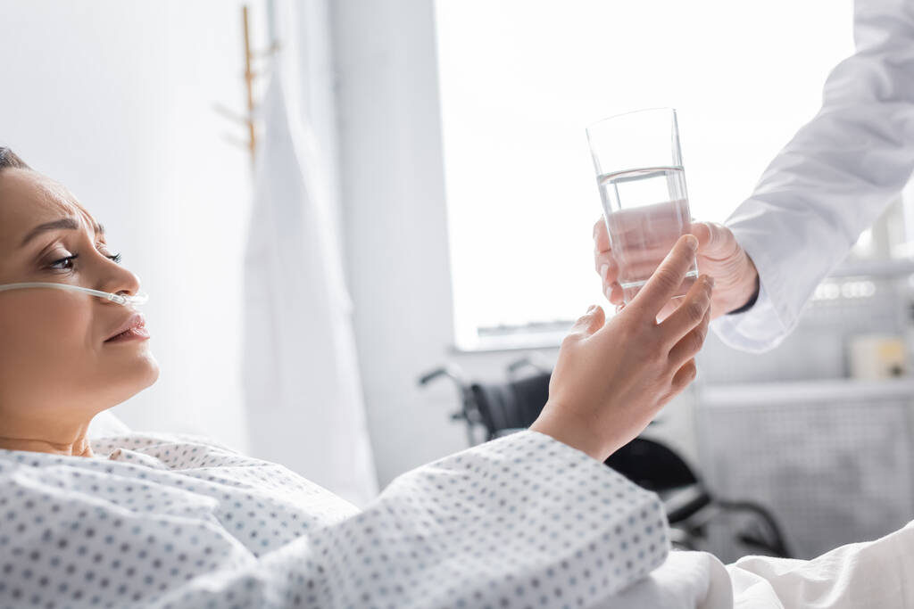 Kranke Afroamerikanerin nimmt Glas Wasser vom Arzt in Klinik - Foto, Bild