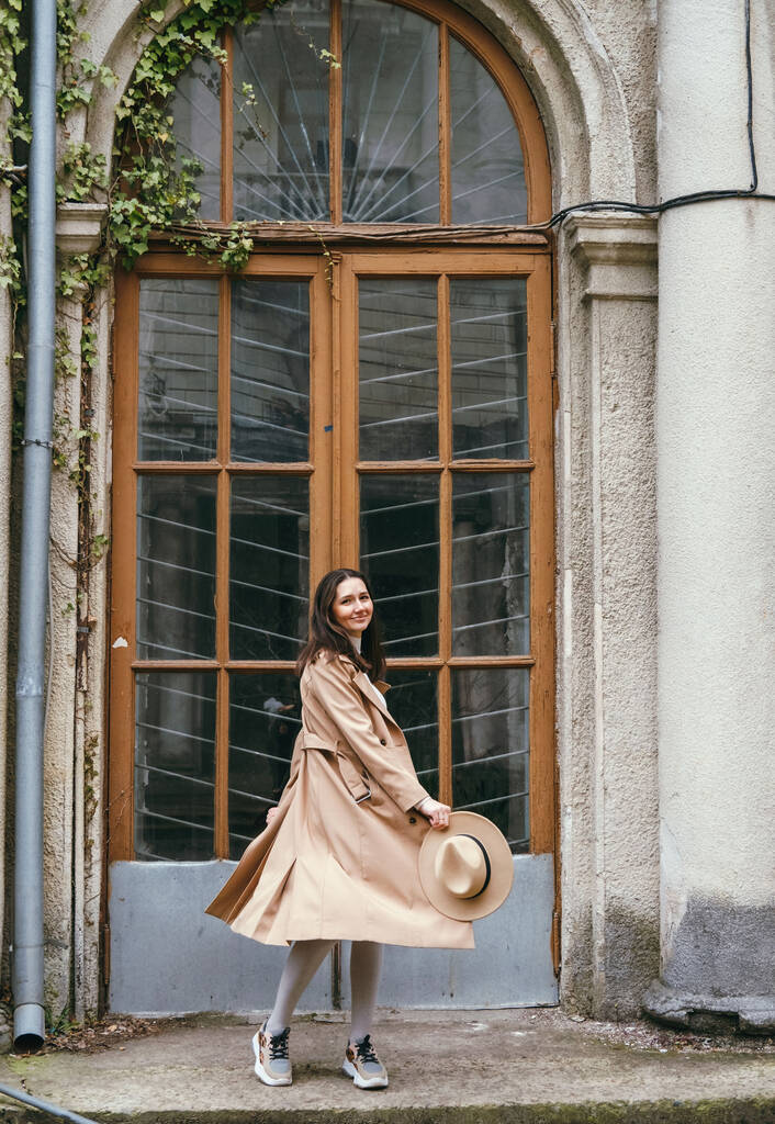 Gündelik giysiler içinde mutlu genç bir kadın eski şehirde yürüyor, seyahat ve moda konsepti. - Fotoğraf, Görsel