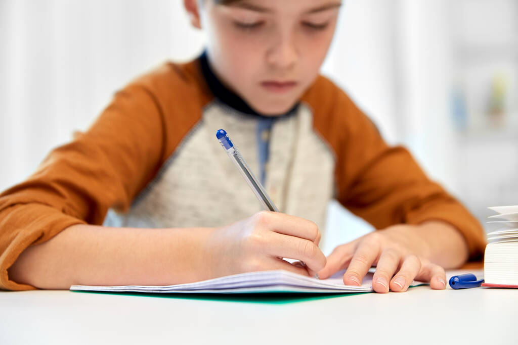 étudiant garçon avec écriture de livre pour ordinateur portable à la maison - Photo, image
