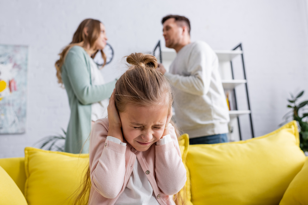 Dívka zakrývající uši blízko rodičů hádající se doma  - Fotografie, Obrázek