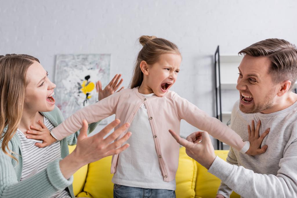 Кричащий ребенок отталкивает ссорящихся родителей  - Фото, изображение