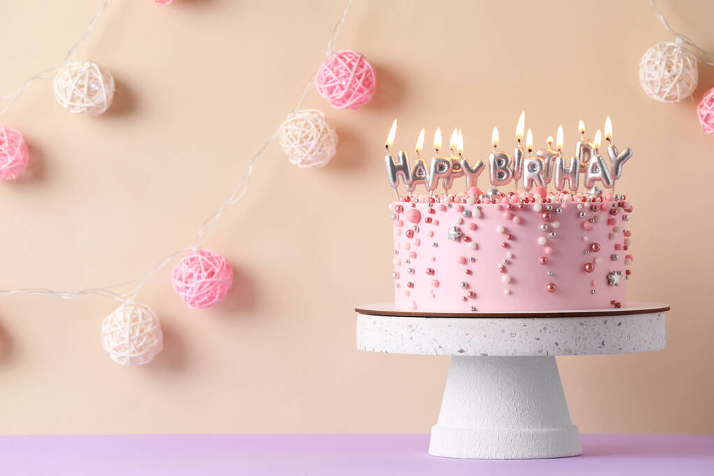 Торт на день народження з палаючими свічками на фіолетовому столі, простір для тексту
 - Фото, зображення