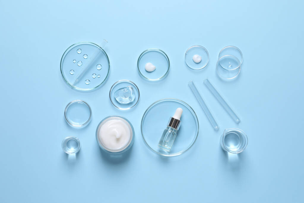 Laboratory glassware and natural ingredients for organic cosmetic product on light blue background, flat lay - Photo, Image