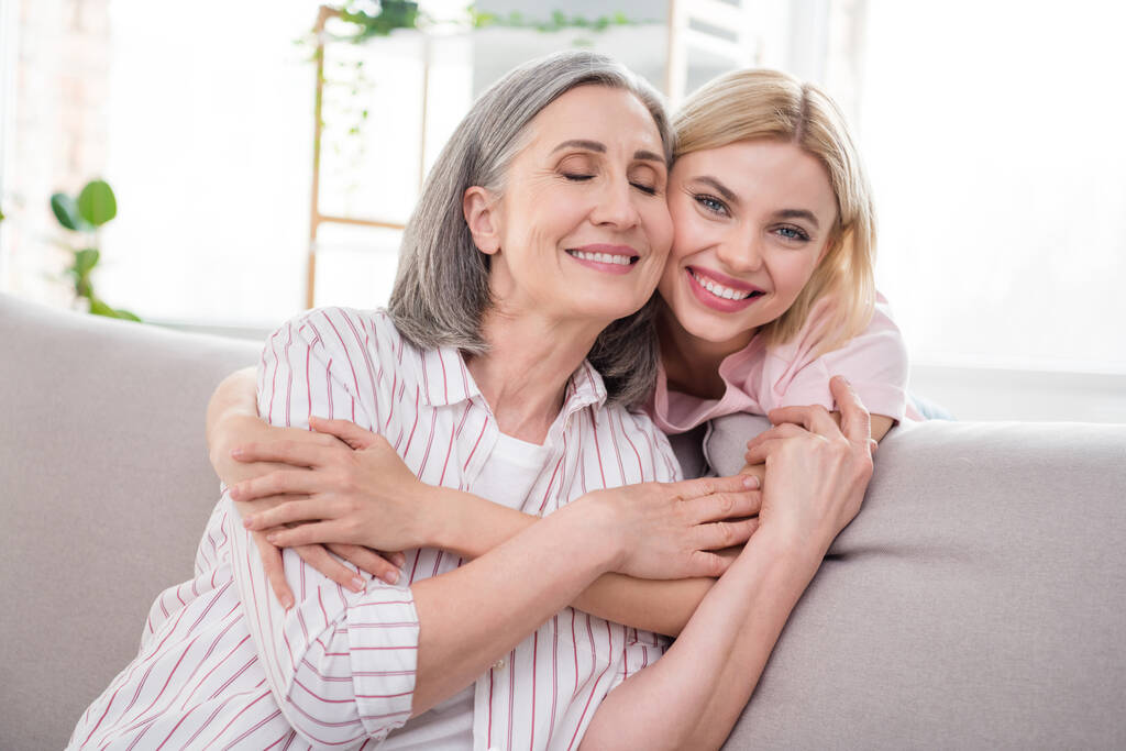 Retrato de duas atraentes doces sonhadoras mulheres alegres neta abraçando a avó em casa interior - Foto, Imagem