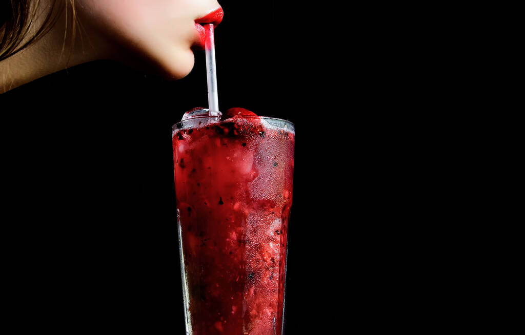 Sensual lips and summer cocktail with strawberry for young girl isolated on black. Thirst and refresh. woman drink cocktail with ice cube, copy space. - Photo, Image