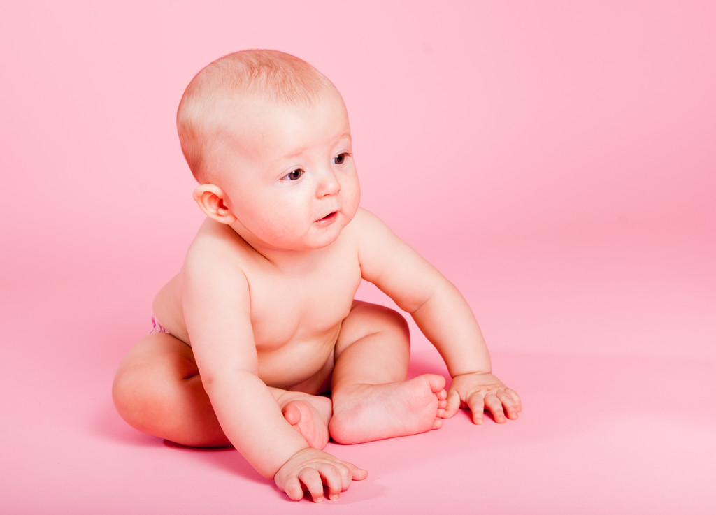 malé baculatý dítě sedí na růžovém pozadí - Fotografie, Obrázek