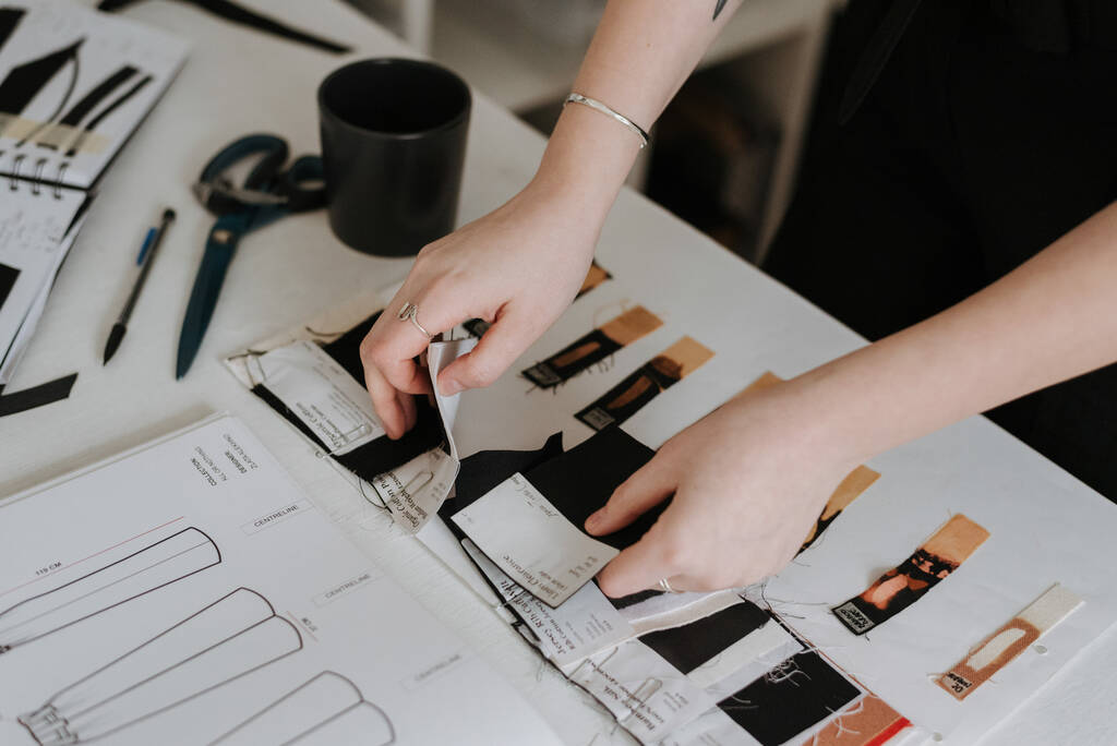 Uma jovem empresária e designer de moda revisando seus esboços de design de roupas - Foto, Imagem
