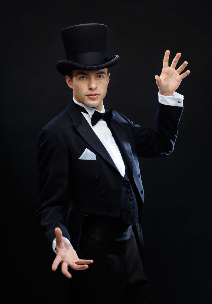 Mágico no chapéu superior mostrando truque
 - Foto, Imagem