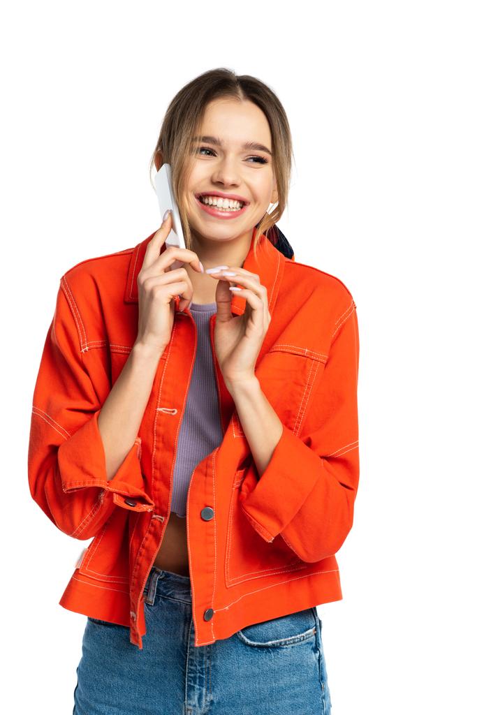 jovem alegre na camisa laranja falando no smartphone isolado no branco - Foto, Imagem
