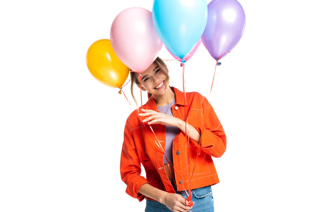 щаслива молода жінка в помаранчевій сорочці тримає барвисті кульки ізольовані на білому
 - Фото, зображення