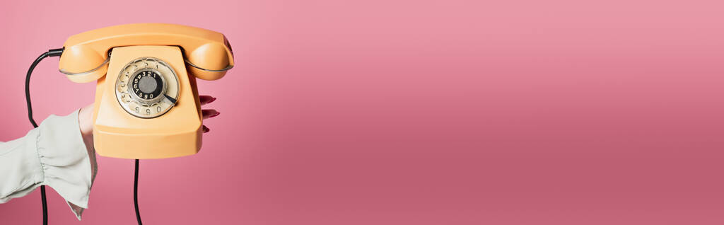 Vágott kilátás nő gazdaság vintage telefon elszigetelt rózsaszín, banner  - Fotó, kép