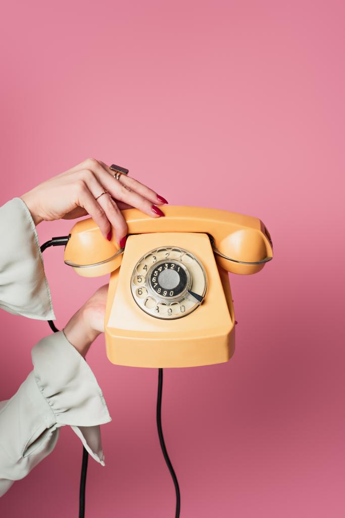 Vágott kilátás nő gazdaság retro telefon elszigetelt rózsaszín  - Fotó, kép