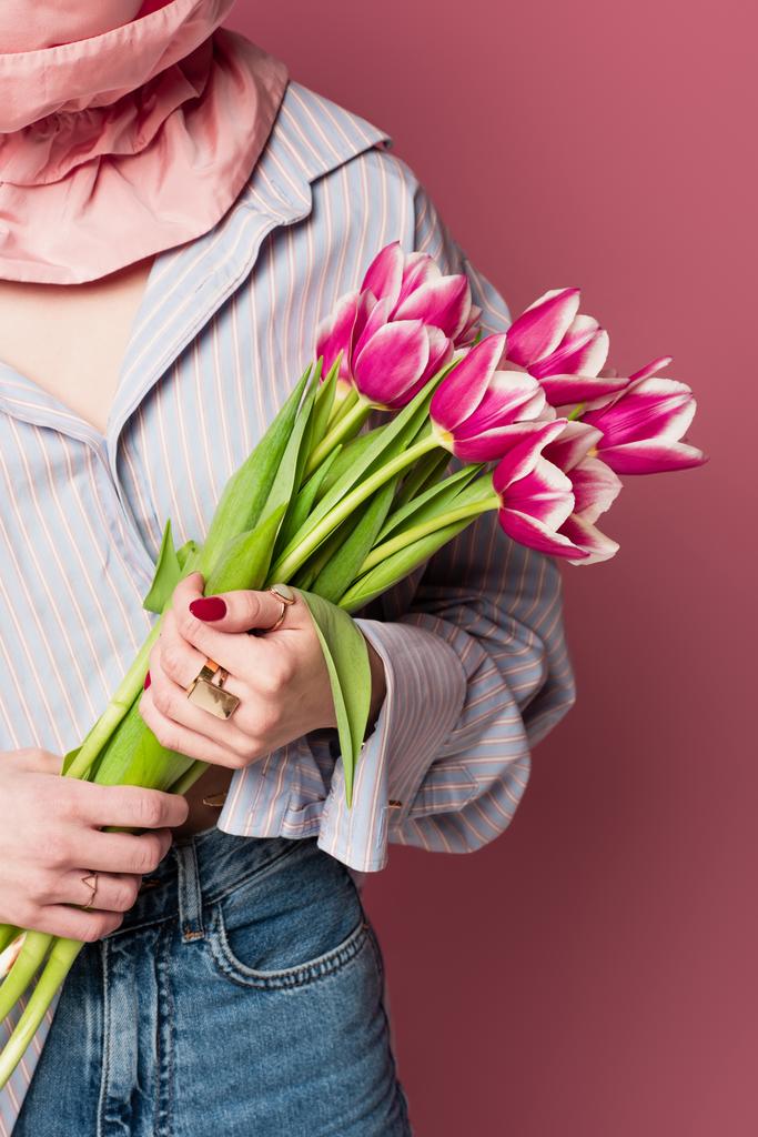 Widok upraw młodej kobiety trzymającej tulipany na różowym tle  - Zdjęcie, obraz