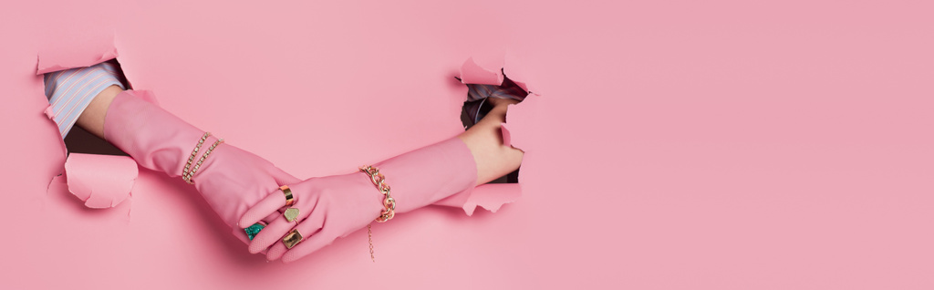 Gesneden weergave van de handen van de vrouw in handschoenen en accessoires in de buurt van roze achtergrond met gaten, banner  - Foto, afbeelding