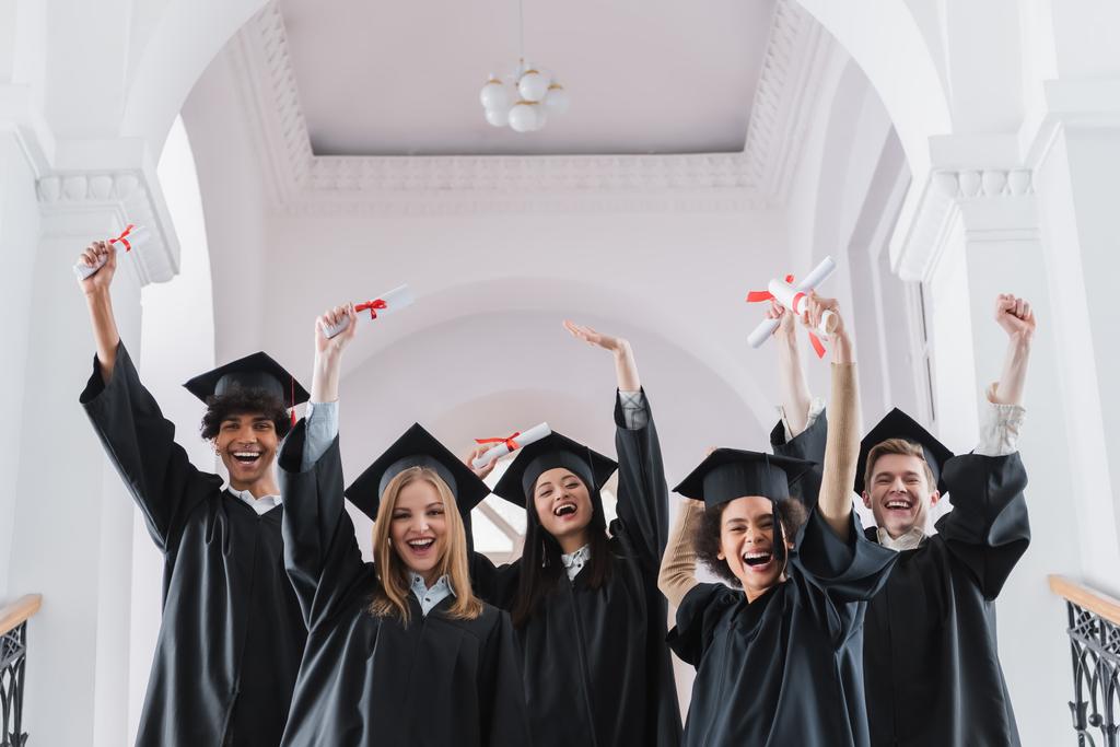 Nadšení multikulturní studenti s diplomy ukazujícími ano gesto  - Fotografie, Obrázek