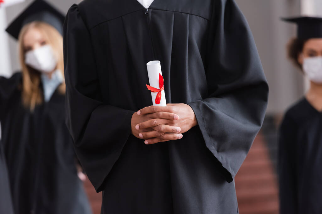Vista cortada de estudante afro-americano em vestido acadêmico com diploma  - Foto, Imagem