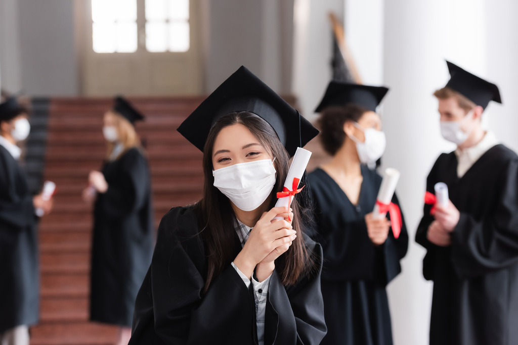 Üniversitede diploması olan koruyucu maskeli Asyalı bekar.  - Fotoğraf, Görsel