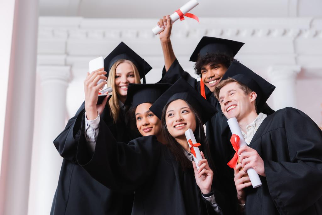 Interraciale afgestudeerden met diploma 's selfie op de universiteit  - Foto, afbeelding