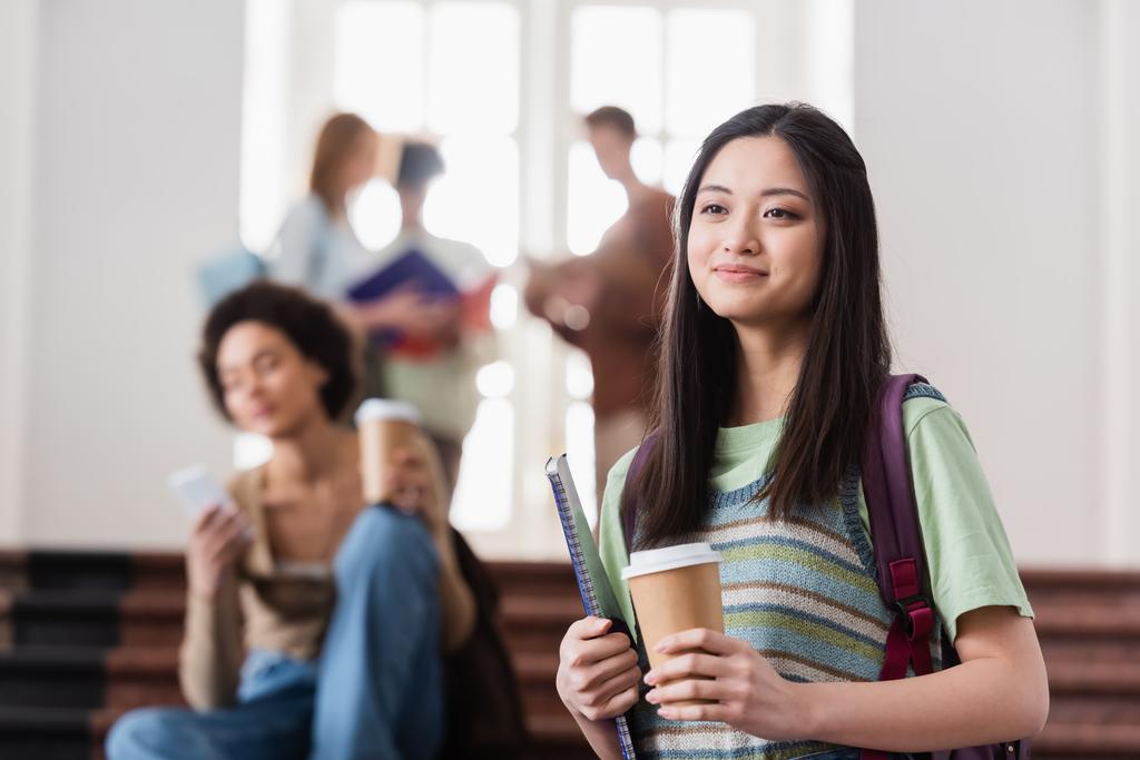 Studente asiatico con caffè per andare e notebook in università  - Foto, immagini