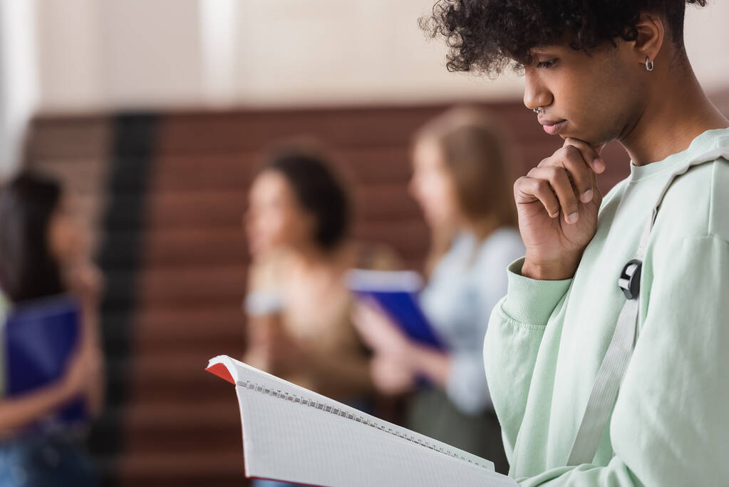 Сторона зору афроамериканського студента, який дивиться на блокнот в університеті.  - Фото, зображення