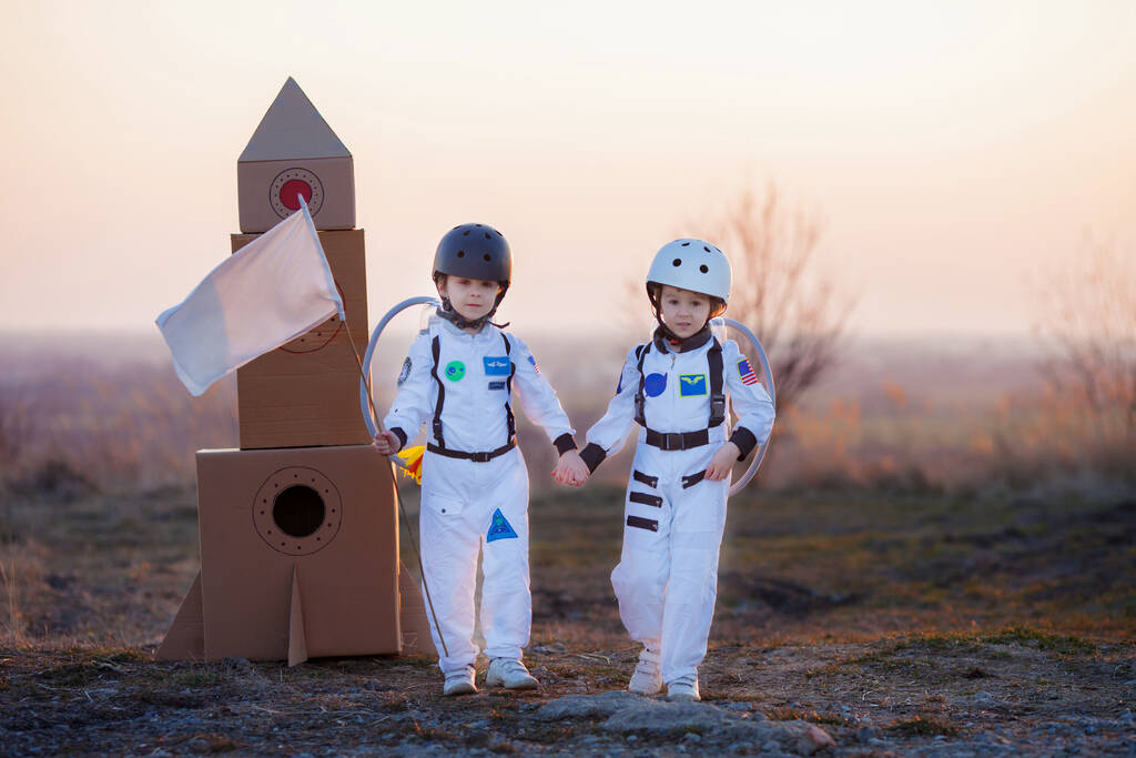 Duas crianças adoráveis, irmãos meninos, brincando no parque ao pôr-do-sol, vestidas como astronautas, imaginando que estão voando na lua - Foto, Imagem