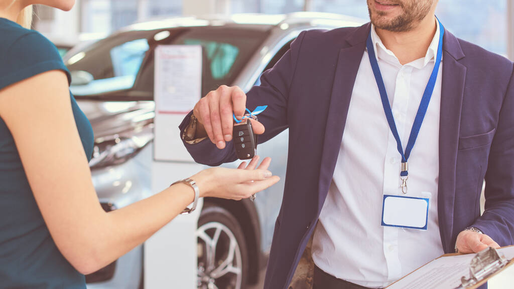 Vendedor de coches vende un coche a cliente feliz en concesionario de coches y las manos sobre las llaves
 - Foto, Imagen