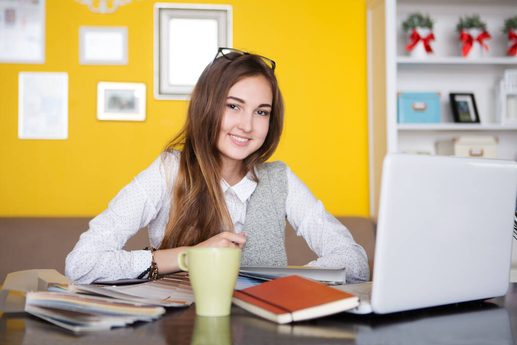  attractive young woman  designer  working with laptop in the home, drinking coffee. home office. - Photo, Image