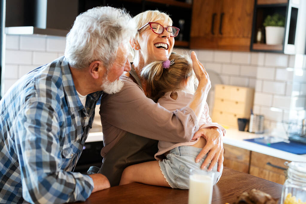 Heureux grands-parents souriants jouant avec leur petite-fille - Photo, image