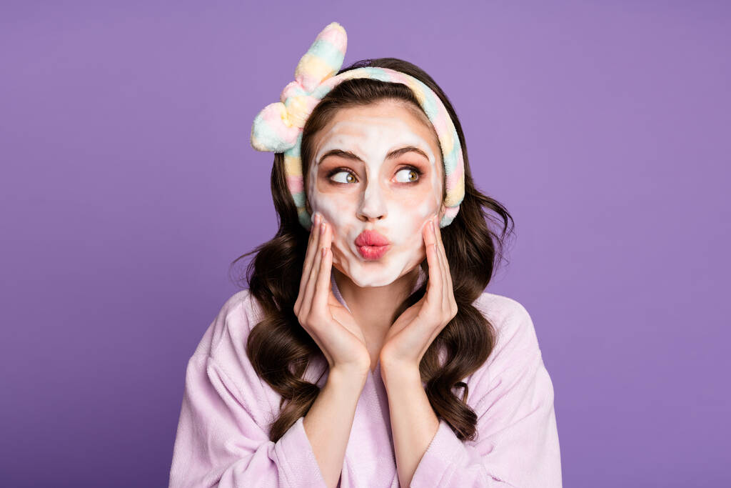 Retrato fotográfico de una chica curiosa aplicando espuma limpiadora mirando el espacio en blanco con los labios acurrucados aislados sobre un fondo de color violeta brillante - Foto, imagen