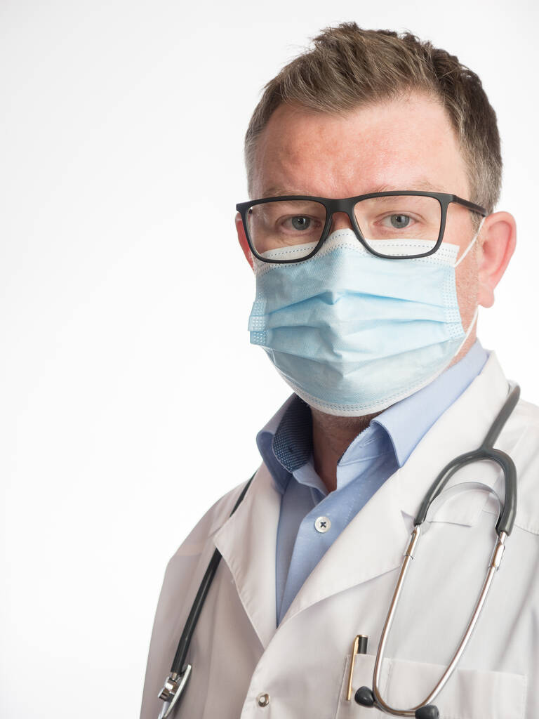 Porträt eines Arztes mit Gesichtsmaske auf weißem Hintergrund - Foto, Bild