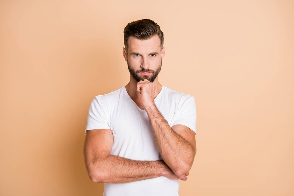 Foto di giovane bell'uomo pensare meditare pensoso grave mano tocco mento isolato su sfondo di colore beige - Foto, immagini