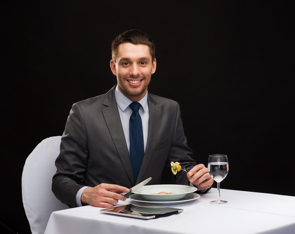 homme souriant avec tablette pc manger plat principal
 - Photo, image