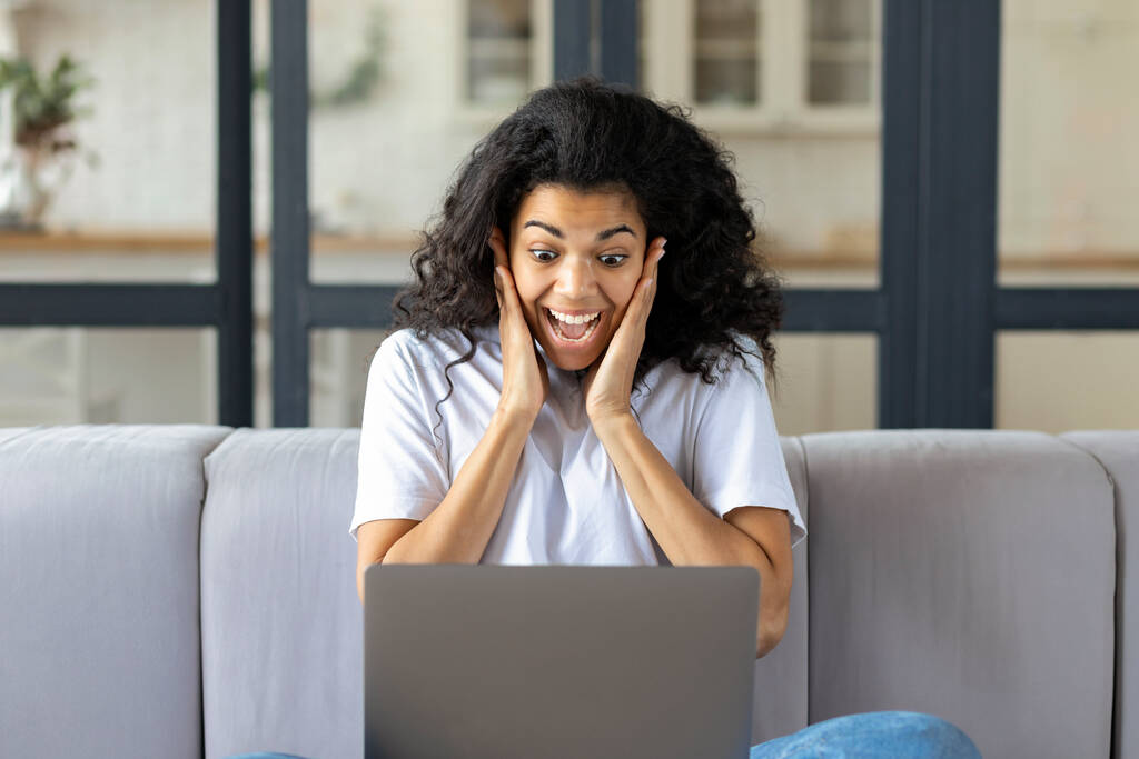 Mulher afro-americana feliz animado sentado no sofá em casa sentir eufórico ganhar loteria on-line ou receber e-mail no laptop com grande notícia, Recrutamento - Foto, Imagem