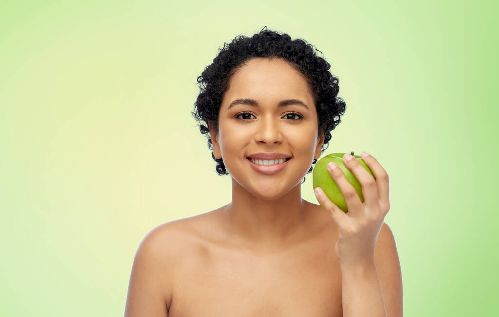boldog afro-amerikai nő kezében zöld alma - Fotó, kép