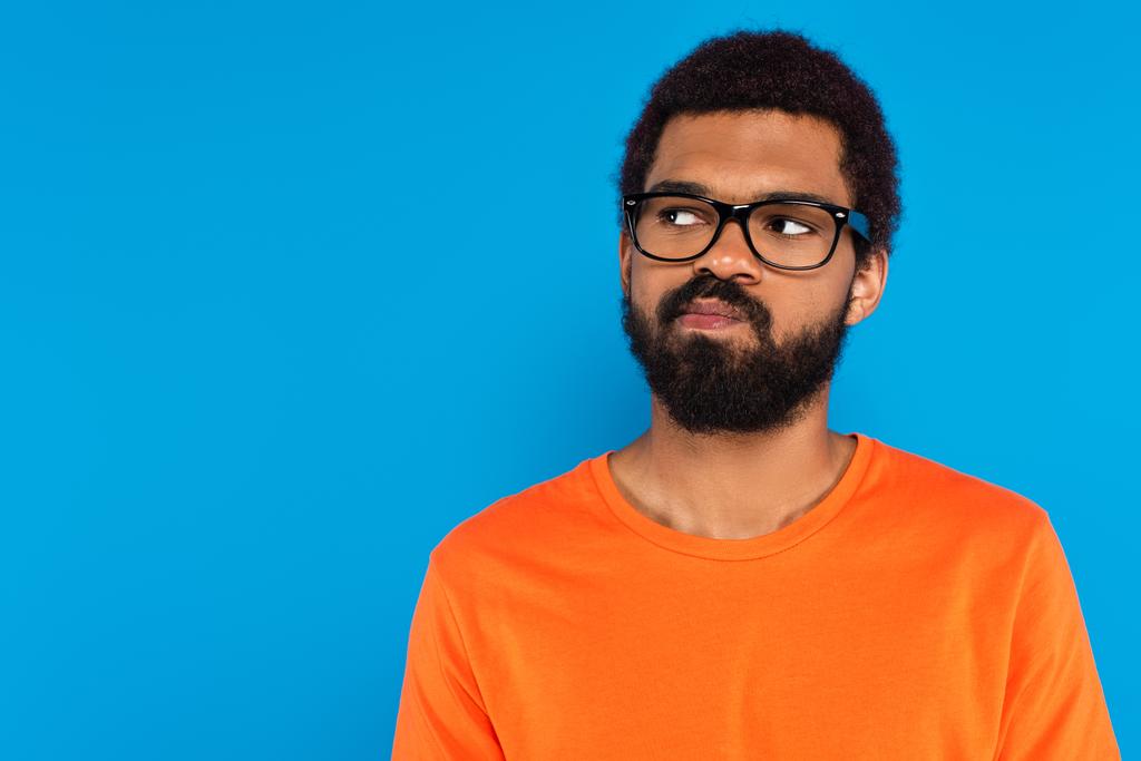 αμφίβολος Αφροαμερικάνος με γυαλιά απομονωμένος σε μπλε - Φωτογραφία, εικόνα