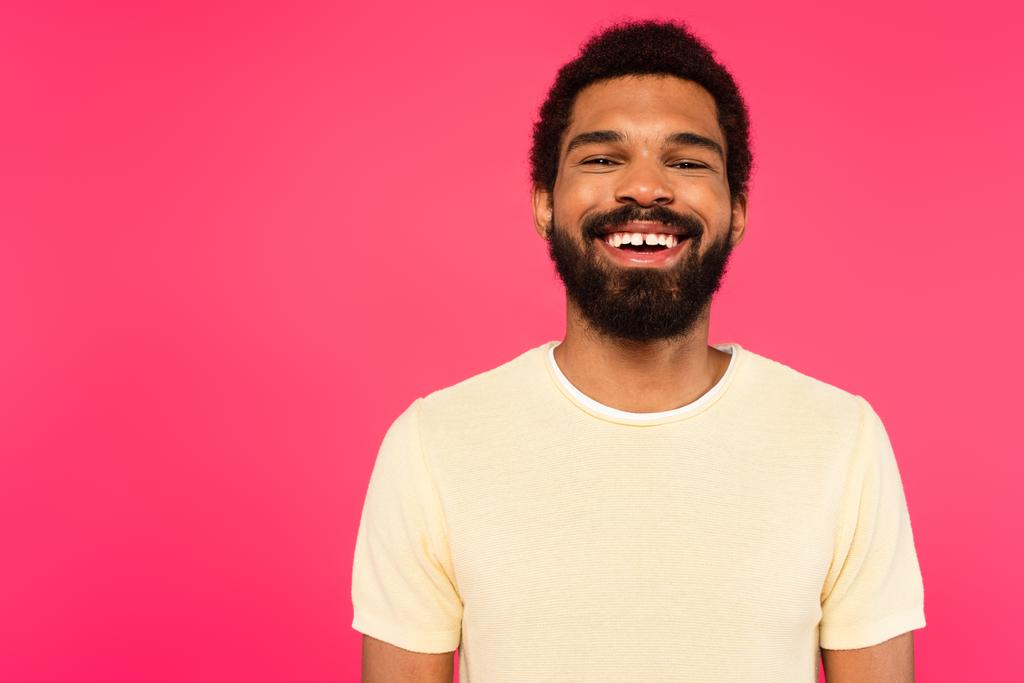 веселый и бородатый африканский американец улыбается изолированный на розовый  - Фото, изображение
