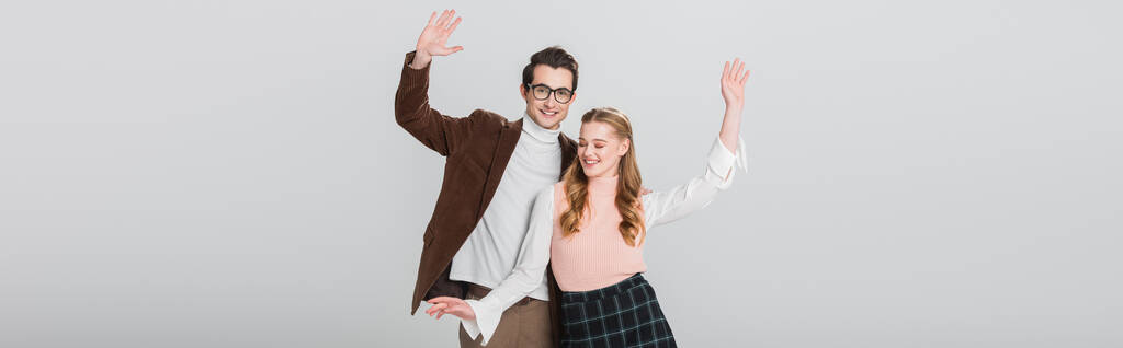 ευτυχισμένο ζευγάρι σε vintage ρούχα που χορεύουν με υψωμένα χέρια απομονώνονται σε γκρι, banner - Φωτογραφία, εικόνα