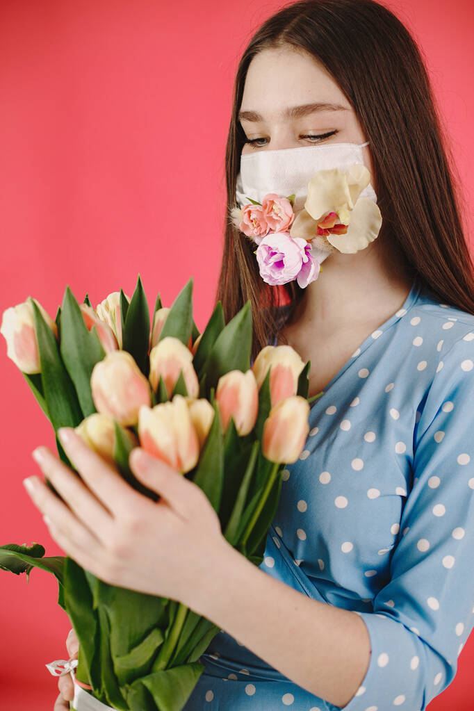 Lány egy maszk virágokkal a piros háttér - Fotó, kép