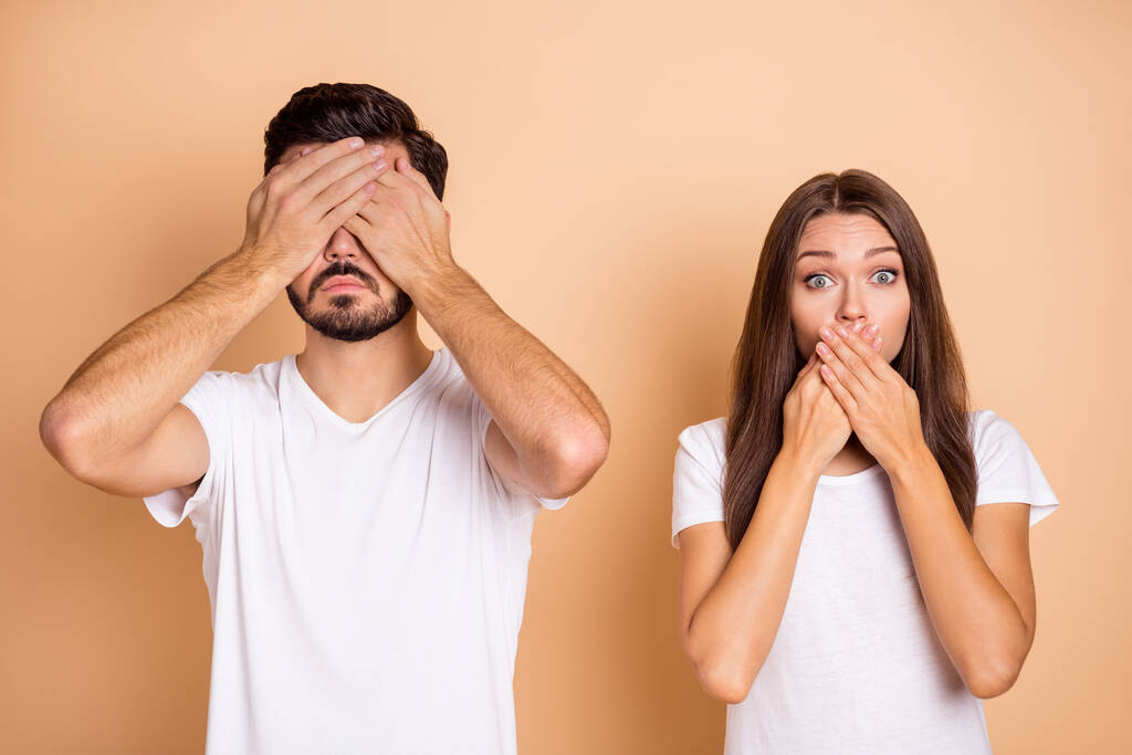 Foto des jungen Paares Mann schließen Augen Frau bedecken Lippen Angst nervöse Panik scheitern Fehler isoliert über beige Farbe Hintergrund - Foto, Bild