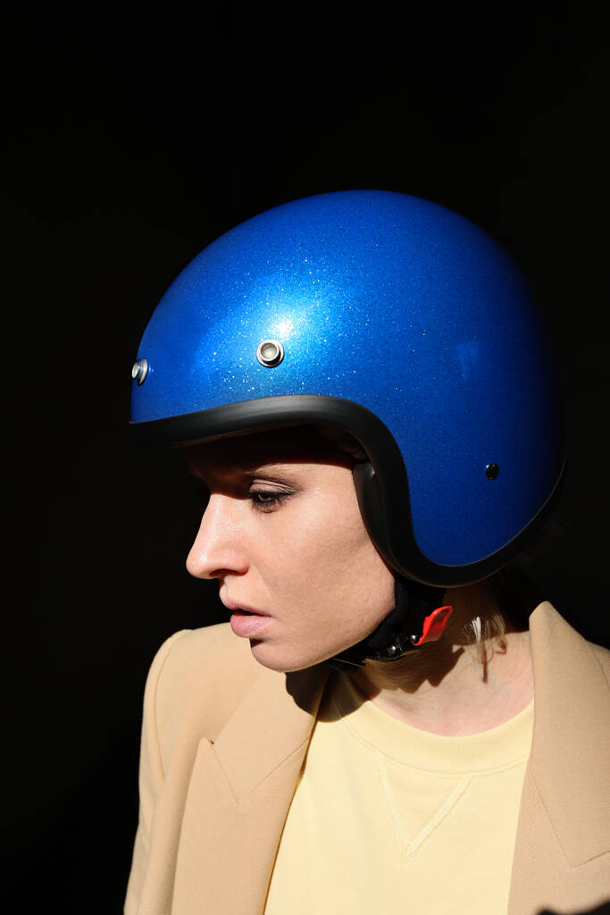 Jonge motorrijder vrouw poseren met blauwe retro helm. Verticaal. - Foto, afbeelding