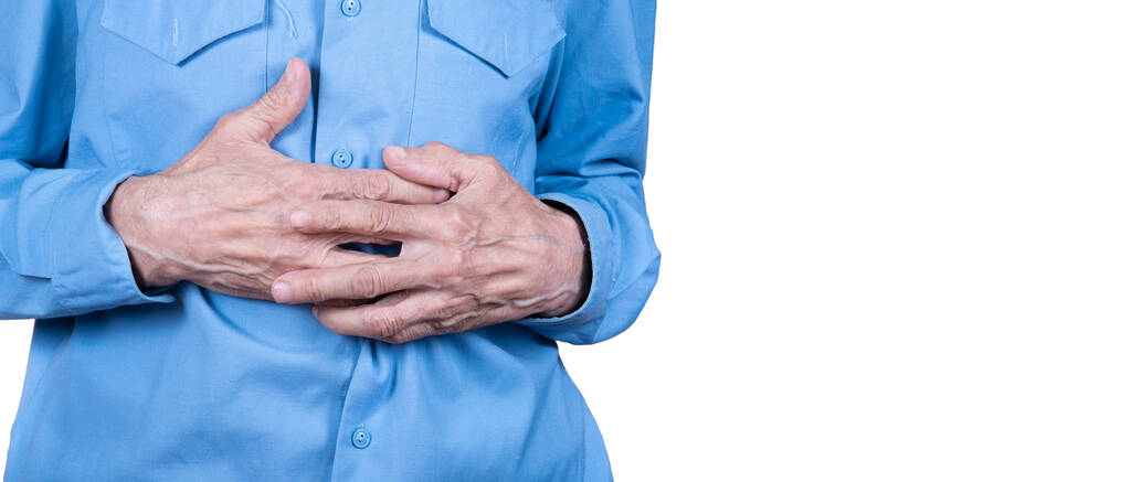 Пожилой мужчина держит за руки желудок, страдает от боли в животе изолирован на белом фоне. Копирование пространства. - Фото, изображение