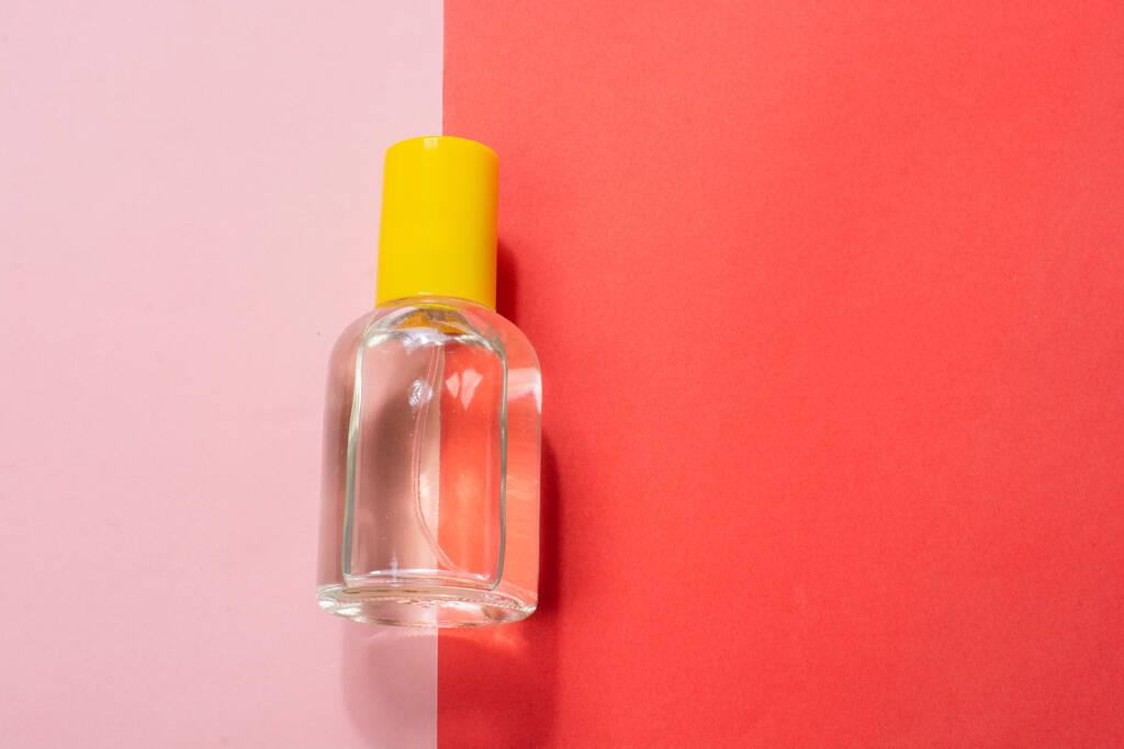 Накладные расходы на съемку маленькой бутылочки на розовом и красном фоне - Фото, изображение