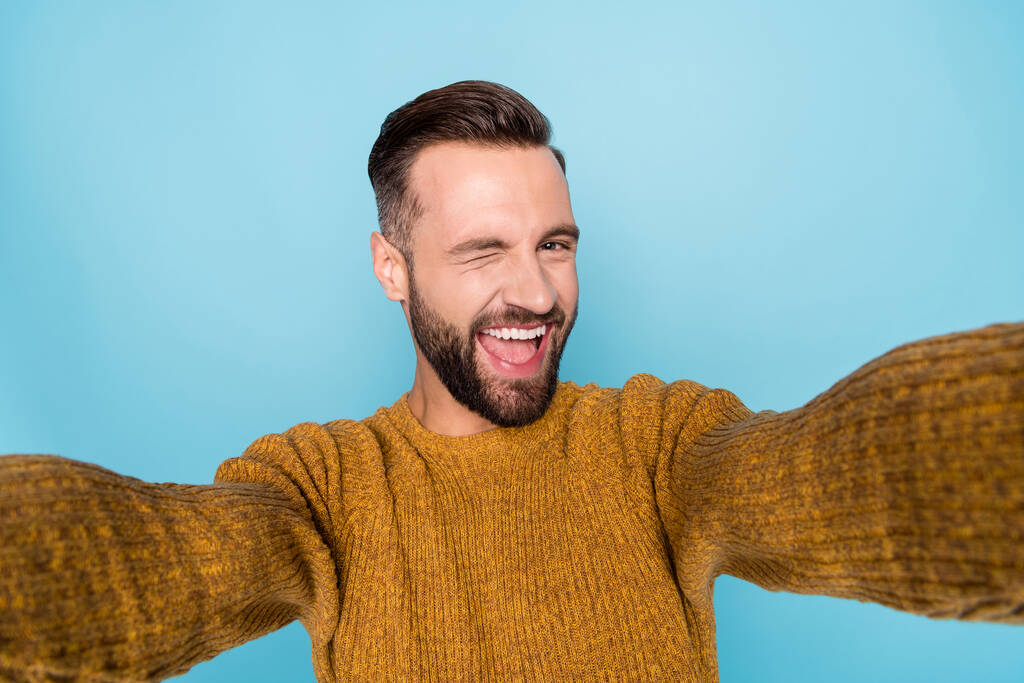 Kuva nuori onnellinen hymyilevä positiivinen iloinen komea mies ottaa selfie vinkki silmä eristetty sininen väri tausta - Valokuva, kuva