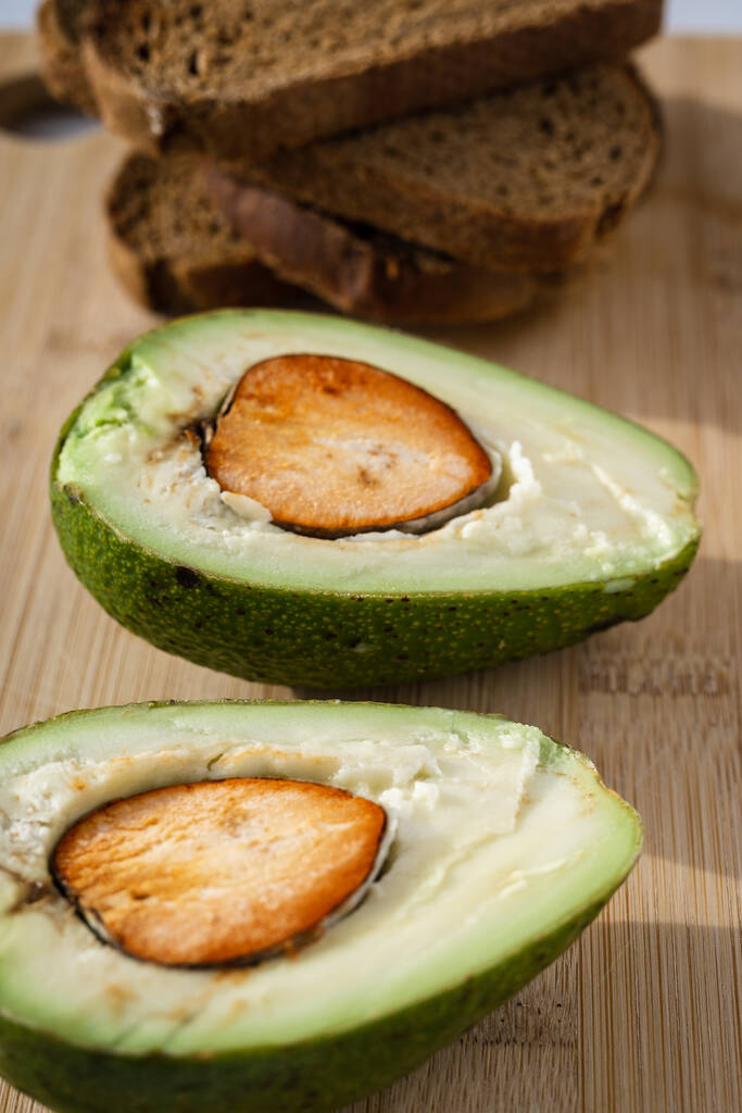 Gezond eten. Avocado met brood toast op een houten tafel. - Foto, afbeelding