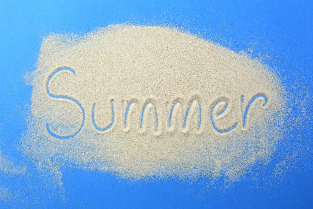 Slovo léto je napsáno v písku na modrém pozadí. - Fotografie, Obrázek